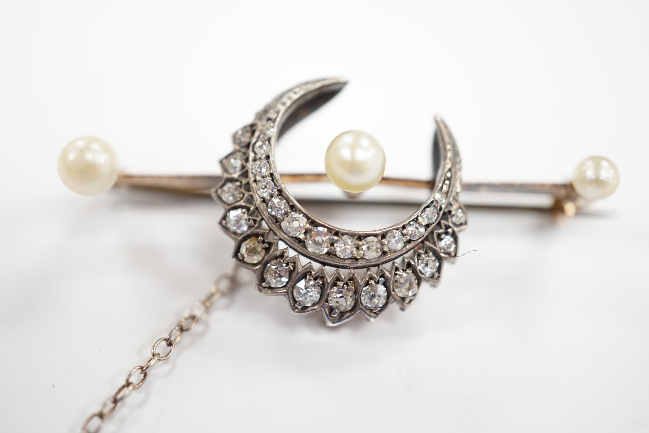 A Victorian yellow and white metal, diamond and pearl set crescent bar brooch, 44mm, gross weight 6.1 grams.
